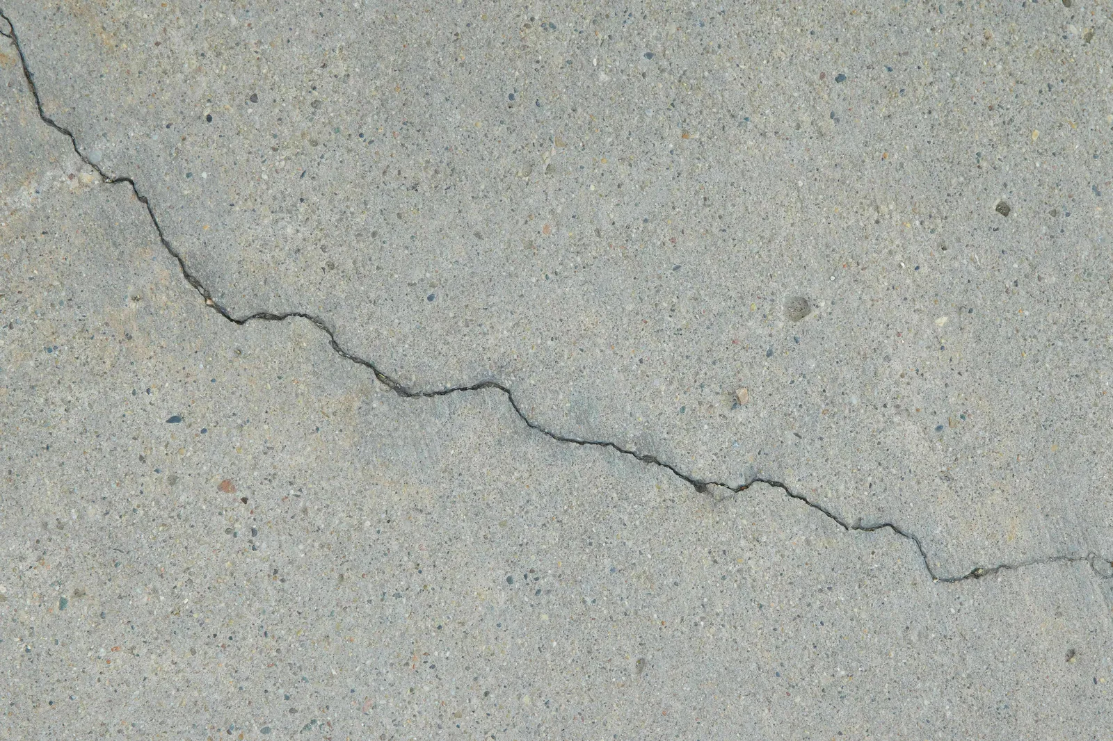 Close-up of a thin crack running across a concrete slab